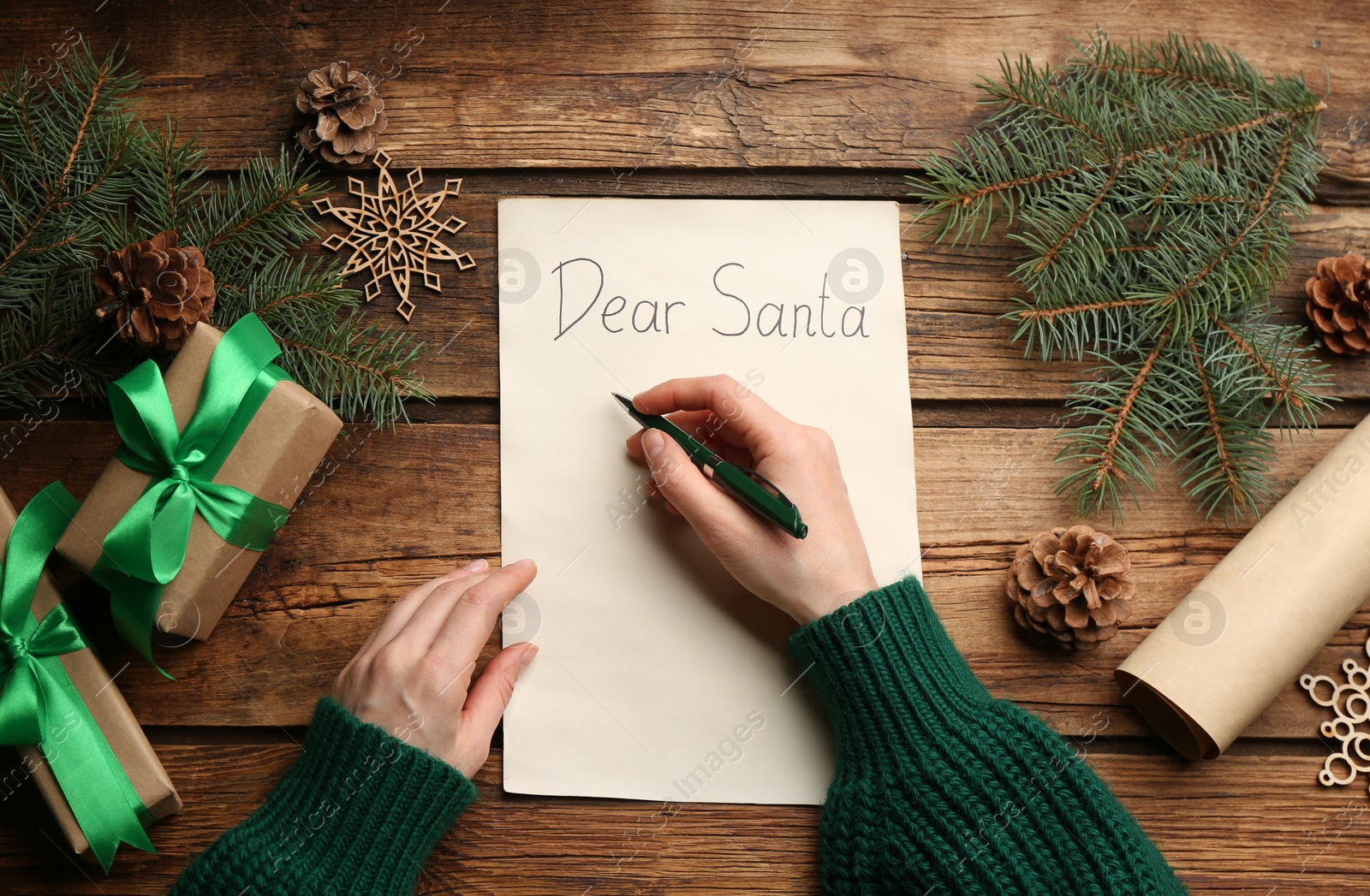Top view of woman writing letter to Santa at wooden table, closeup Photo of Top view of woman writing letter to Santa at wooden table, closeup