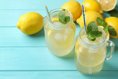 Natural lemonade with mint on light blue wooden table, closeup. Summer refreshing drink Photo of Natural lemonade with mint on light blue wooden table, closeup. Summer refreshing drink