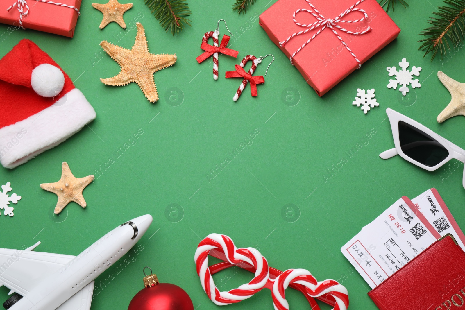 Frame with toy airplane, festive decor, Santa hat and space for text on green background. Christmas vacation Photo of Frame with toy airplane, festive decor, Santa hat and space for text on green background. Christmas vacation