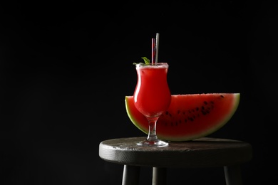 Tasty watermelon drink and fresh fruit on table against black background, space for text Photo of Tasty watermelon drink and fresh fruit on table against black background, space for text