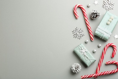 Flat lay composition with candy canes and Christmas decor on grey background. Space for text Photo of Flat lay composition with candy canes and Christmas decor on grey background. Space for text