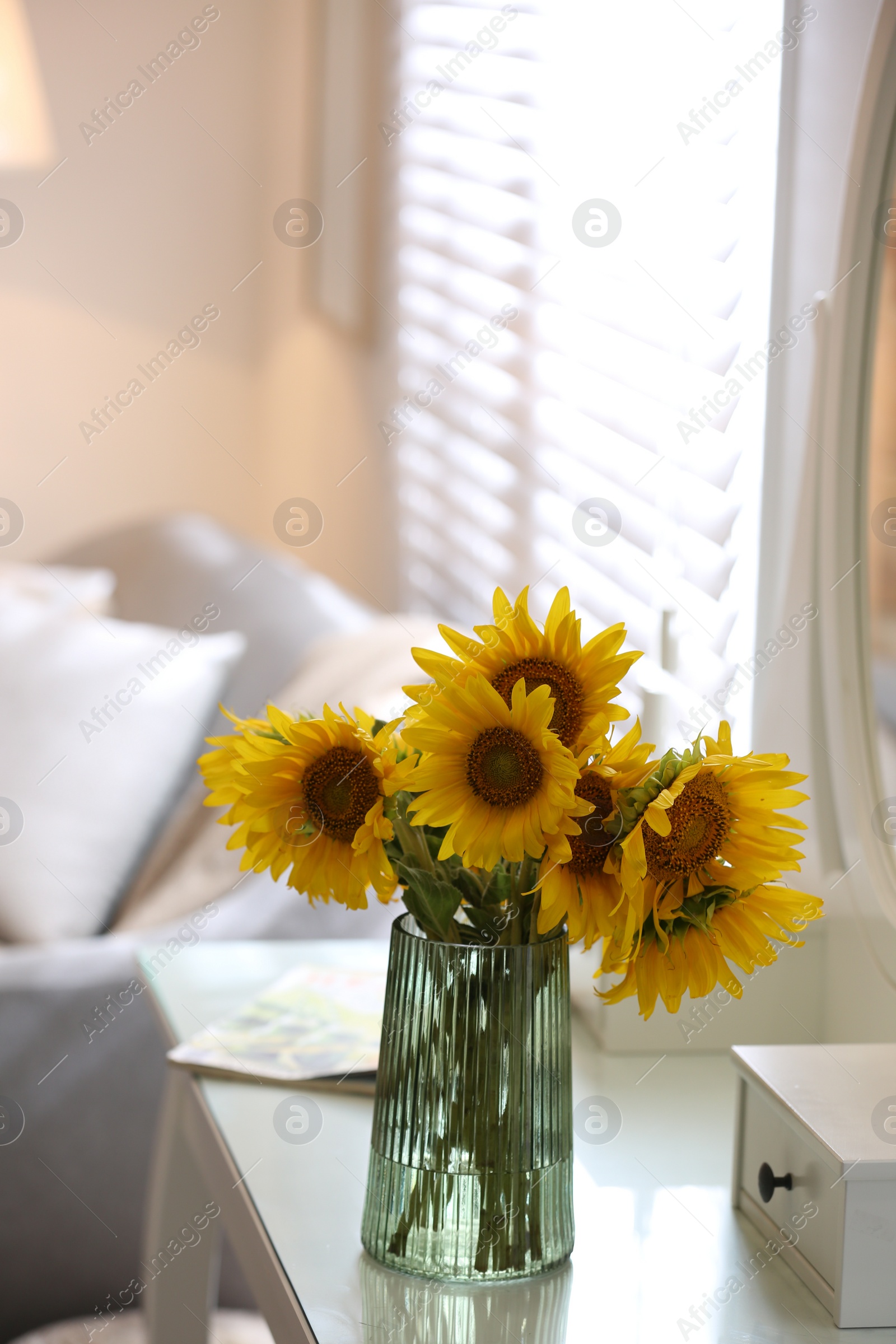 Beautiful bouquet of sunflowers in vase on white table indoors. Space for text Photo of Beautiful bouquet of sunflowers in vase on white table indoors. Space for text