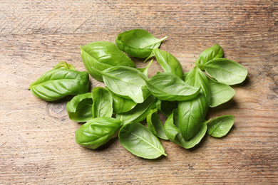 Fresh basil leaves on wooden table, above view Photo of Fresh basil leaves on wooden table, above view