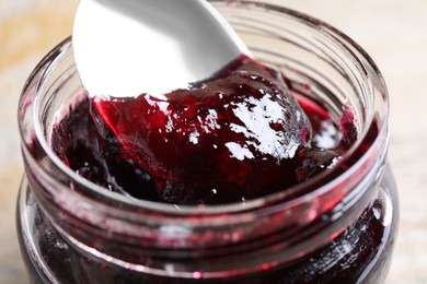 Spoon with berry jam in jar, closeup Image of Spoon with berry jam in jar, closeup