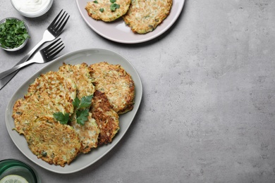 Delicious zucchini fritters served on grey table, flat lay. Space for text Photo of Delicious zucchini fritters served on grey table, flat lay. Space for text