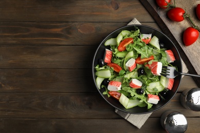 Delicious crab stick salad served on wooden table, flat lay. Space for text Photo of Delicious crab stick salad served on wooden table, flat lay. Space for text