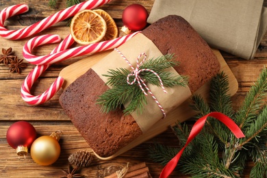 Delicious gingerbread cake, candy canes and Christmas decor on wooden table, flat lay Photo of Delicious gingerbread cake, candy canes and Christmas decor on wooden table, flat lay