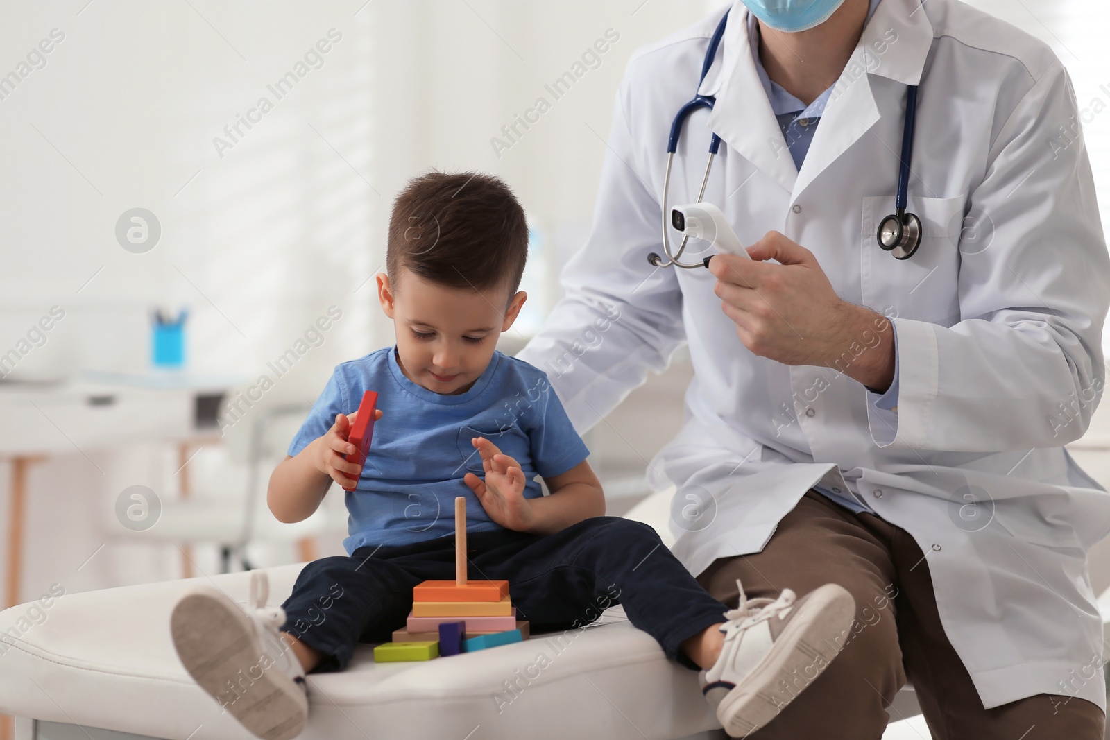 Pediatrician checking little boy's temperature at hospital Photo of Pediatrician checking little boy's temperature at hospital