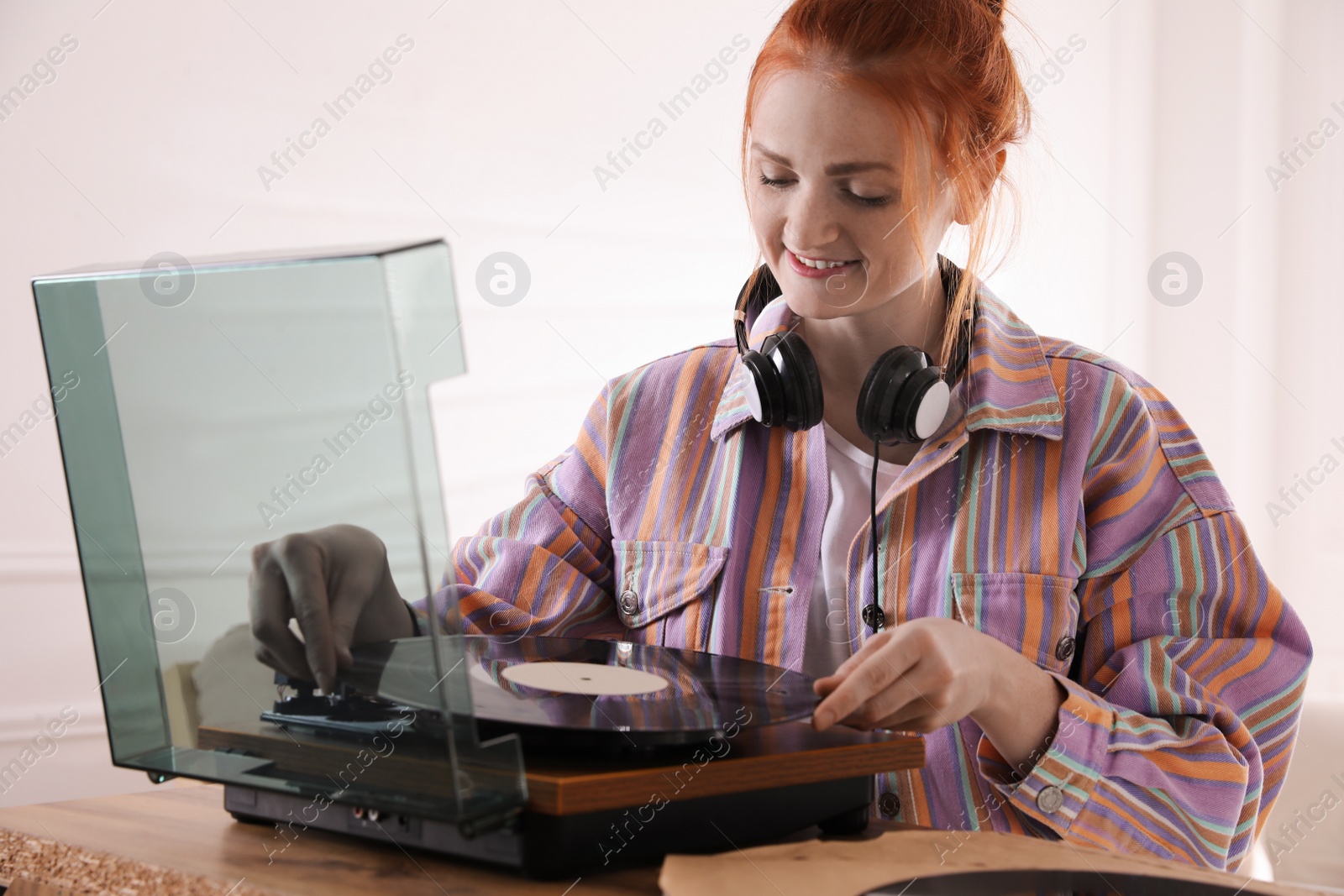 Beautiful young woman using turntable at home Photo of Beautiful young woman using turntable at home