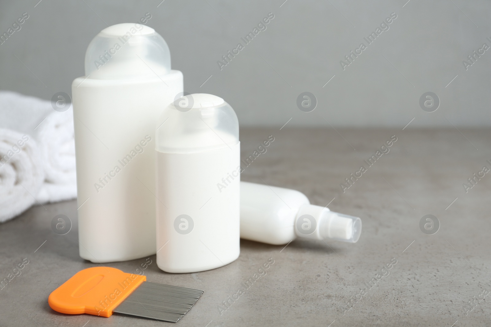 Different cosmetic products and lice comb on grey table. Space for text Photo of Different cosmetic products and lice comb on grey table. Space for text