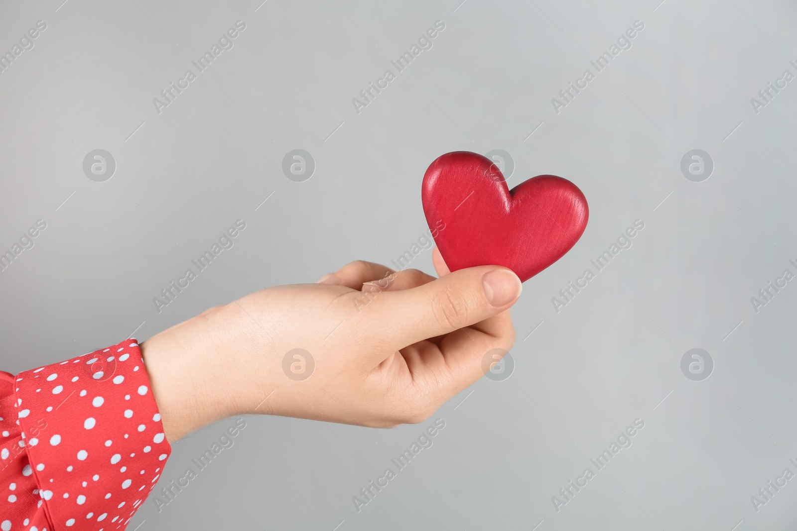 Woman holding red heart on grey background, closeup. Happy Valentine's Day Photo of Woman holding red heart on grey background, closeup. Happy Valentine's Day