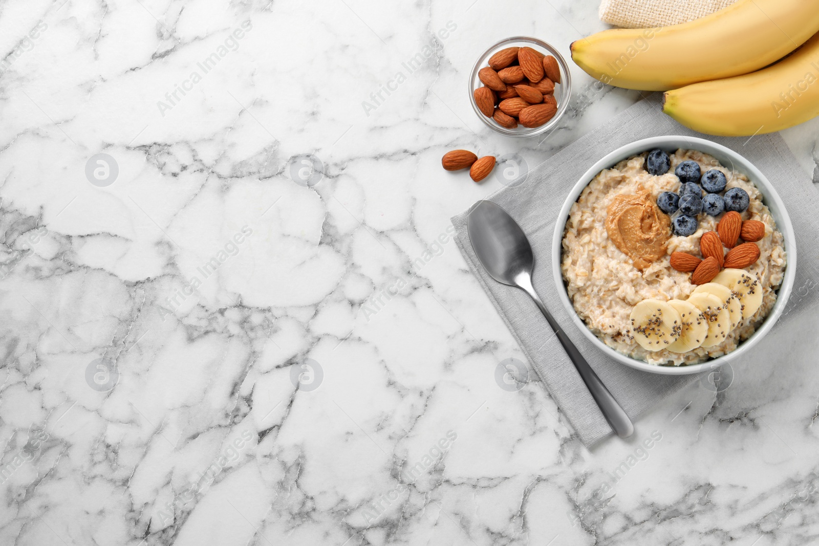 Tasty oatmeal porridge with toppings served on white marble table, flat lay. Space for text Photo of Tasty oatmeal porridge with toppings served on white marble table, flat lay. Space for text