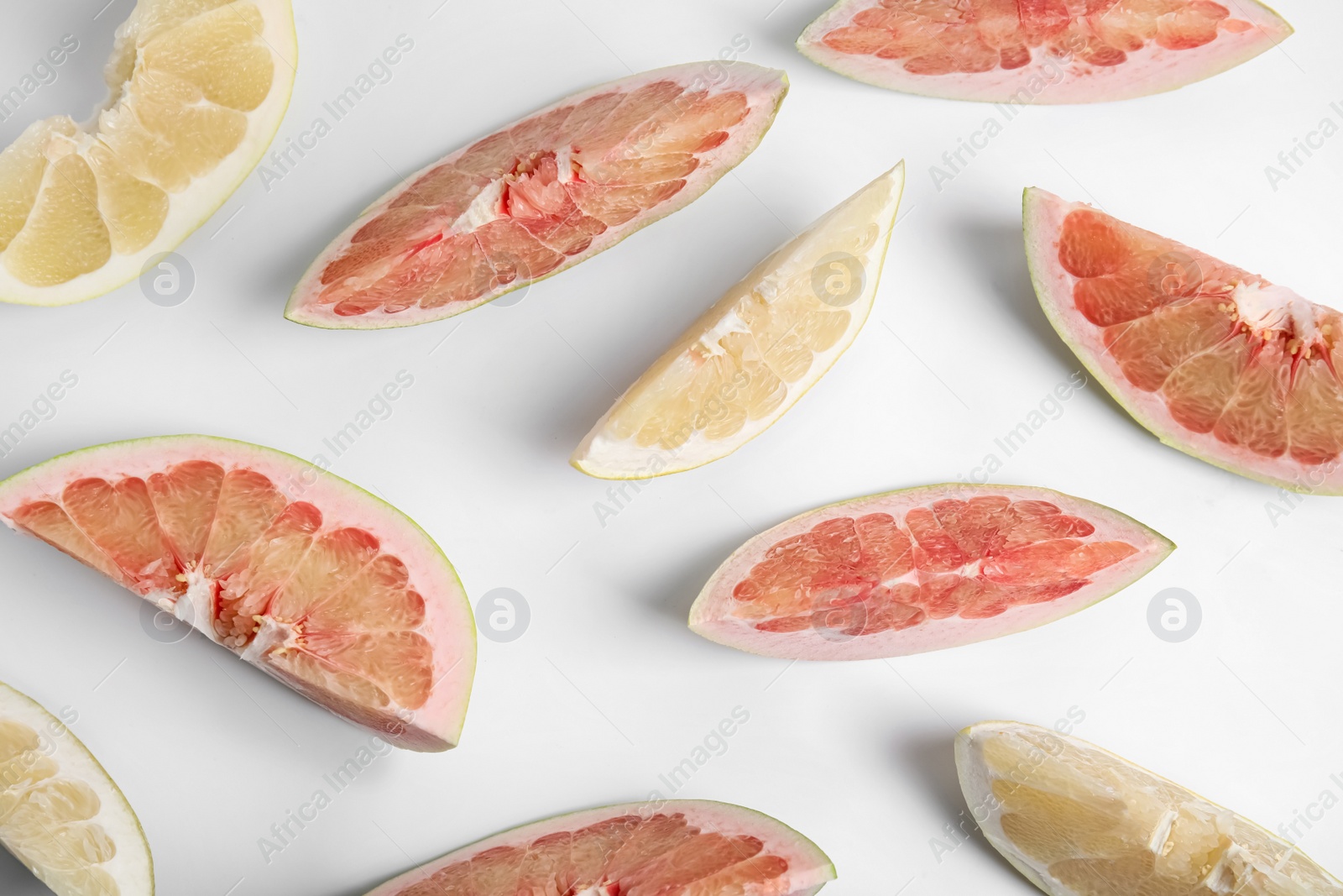 Slices of different ripe pomelos on white background, flat lay Photo of Slices of different ripe pomelos on white background, flat lay