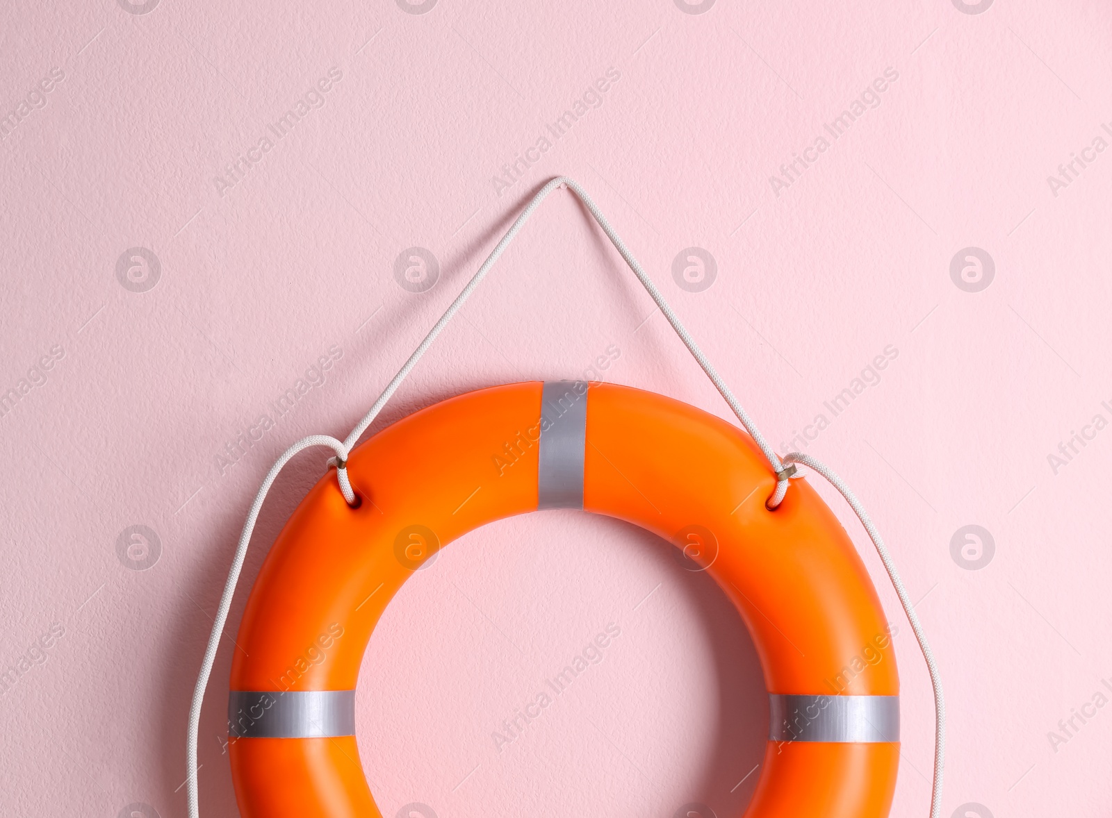 Orange lifebuoy on pink background. Rescue equipment Photo of Orange lifebuoy on pink background. Rescue equipment