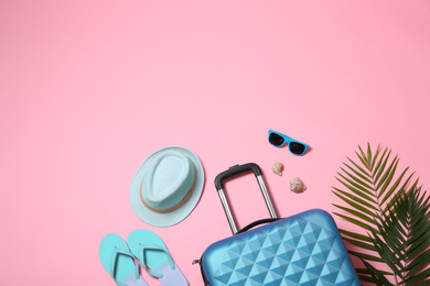 Photo of Flat lay composition with suitcase and space for text on pink background