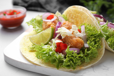 Delicious fish tacos served on light grey table, closeup Photo of Delicious fish tacos served on light grey table, closeup