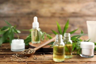 Composition with CBD oil, THC tincture and hemp leaves on wooden table Photo of Composition with CBD oil, THC tincture and hemp leaves on wooden table