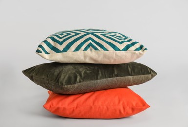 Stack of stylish soft pillows on grey background Photo of Stack of stylish soft pillows on grey background