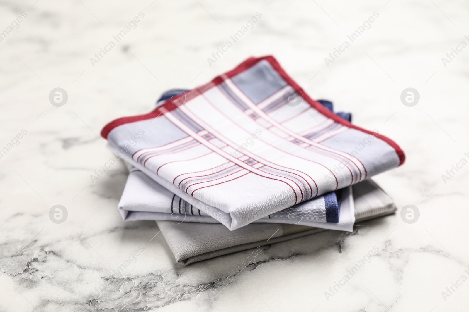 Different handkerchiefs folded on white marble table Photo of Different handkerchiefs folded on white marble table
