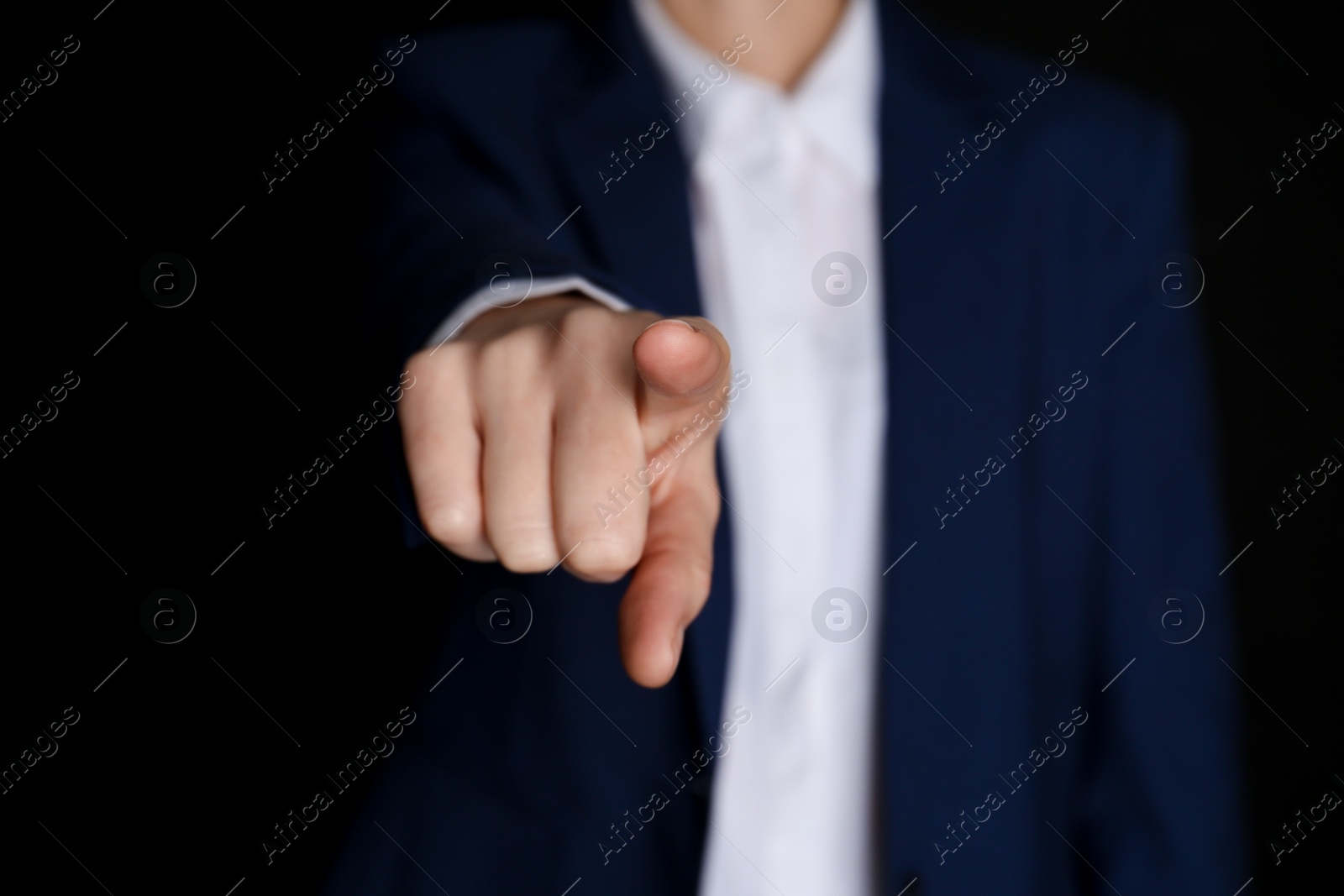 Businesswoman pointing at something on black background, closeup. Finger gesture Photo of Businesswoman pointing at something on black background, closeup. Finger gesture