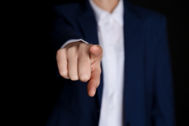 Businesswoman pointing at something on black background, closeup. Finger gesture Photo of Businesswoman pointing at something on black background, closeup. Finger gesture