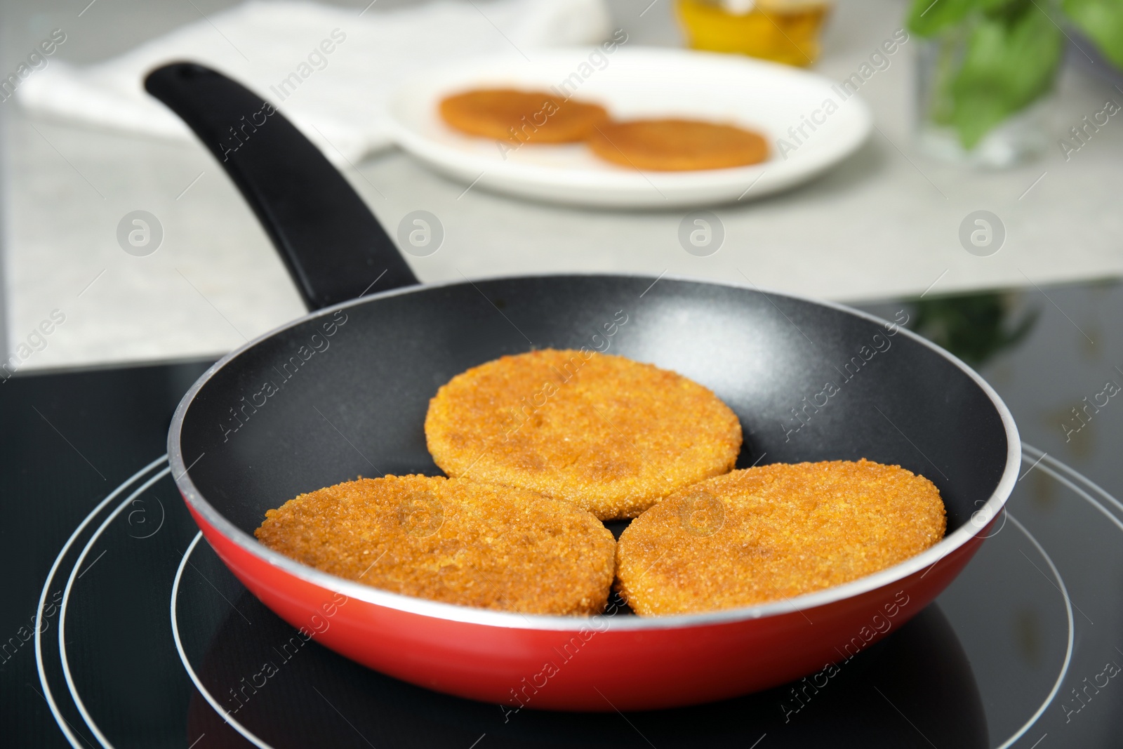 Cooking breaded cutlets in frying pan on stove Photo of Cooking breaded cutlets in frying pan on stove