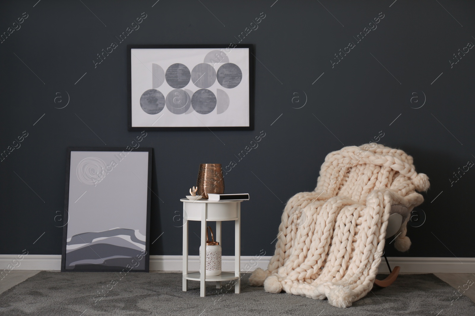 Rocking chair with white knitted plaid in room. Interior design Photo of Rocking chair with white knitted plaid in room. Interior design