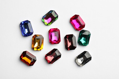 Different beautiful gemstones on white background, top view Image of Different beautiful gemstones on white background, top view