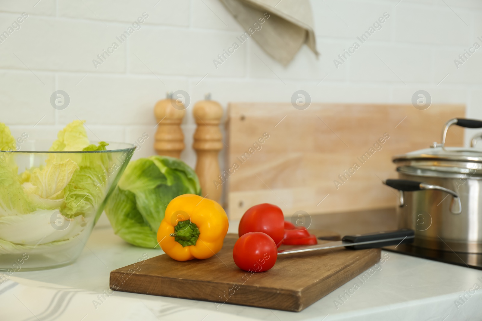 Fresh vegetables on white countertop in modern kitchen Photo of Fresh vegetables on white countertop in modern kitchen