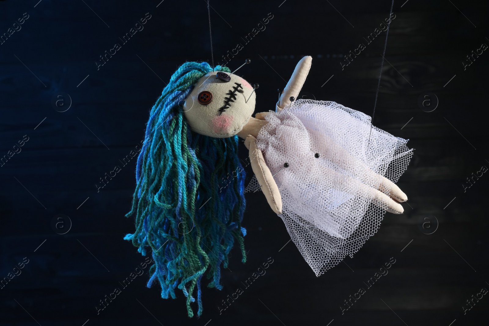 Female voodoo doll with pins on dark background Photo of Female voodoo doll with pins on dark background