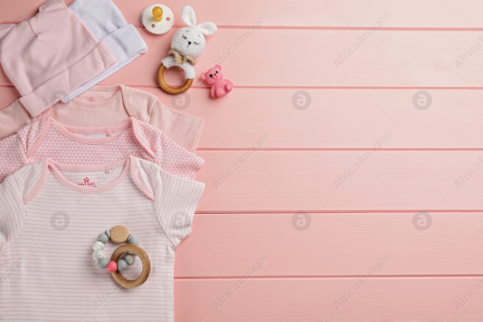 Flat lay composition with baby clothes and accessories on pink wooden background, space for text Photo of Flat lay composition with baby clothes and accessories on pink wooden background, space for text
