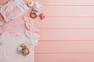 Flat lay composition with baby clothes and accessories on pink wooden background, space for text Photo of Flat lay composition with baby clothes and accessories on pink wooden background, space for text