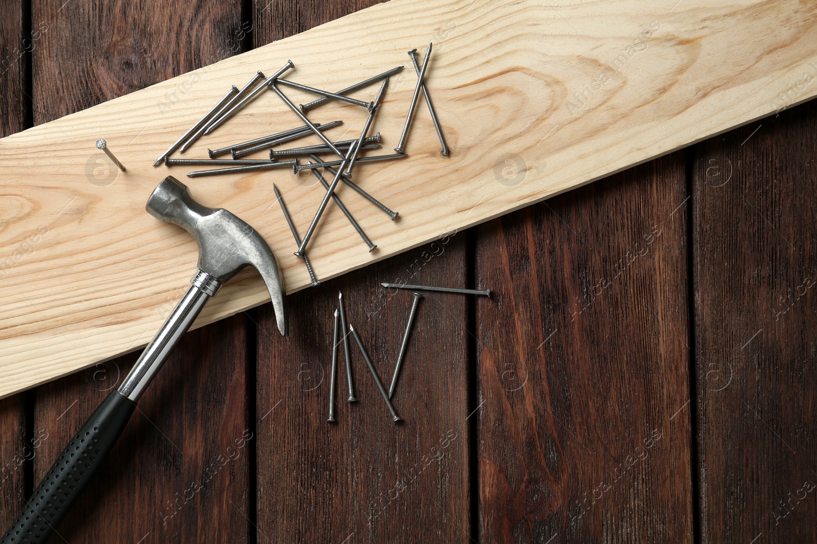 Hammer, plank and metal nails on wooden table, flat lay. Space for text Photo of Hammer, plank and metal nails on wooden table, flat lay. Space for text