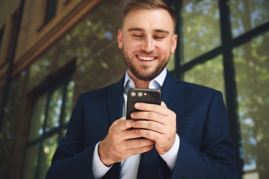 Young man using smartphone outdoors, focus on hands Photo of Young man using smartphone outdoors, focus on hands