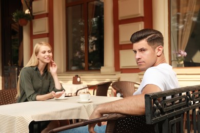 Man having boring date with talkative woman in outdoor cafe Photo of Man having boring date with talkative woman in outdoor cafe