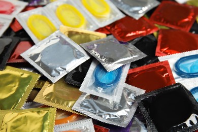 Pile of different condoms as background, closeup Photo of Pile of different condoms as background, closeup