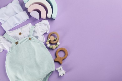 Flat lay composition with baby clothes and accessories on violet background, space for text Photo of Flat lay composition with baby clothes and accessories on violet background, space for text
