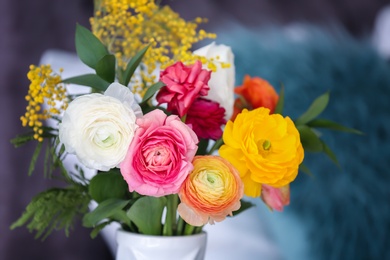 Vase with beautiful ranunculus flowers on blurred background Photo of Vase with beautiful ranunculus flowers on blurred background