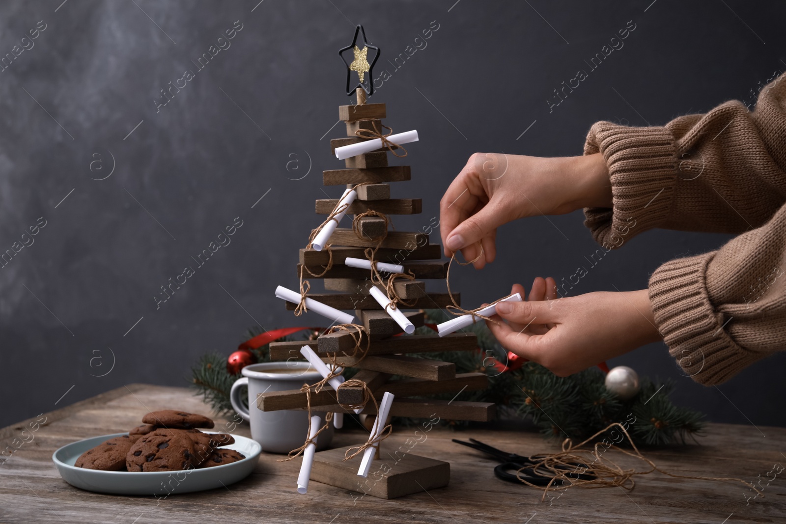 Woman making advent calendar at wooden table, closeup Photo of Woman making advent calendar at wooden table, closeup