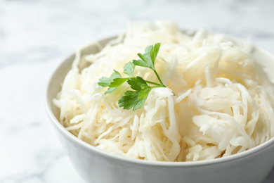 Tasty fermented cabbage with parsley on table, closeup Photo of Tasty fermented cabbage with parsley on table, closeup