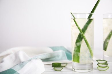 Fresh aloe drink with leaves in glasses on white wooden table. Space for text Photo of Fresh aloe drink with leaves in glasses on white wooden table. Space for text