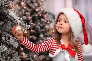 Cute little child near Christmas tree at home Photo of Cute little child near Christmas tree at home