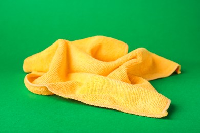 Orange microfiber cloth on green background, closeup Photo of Orange microfiber cloth on green background, closeup