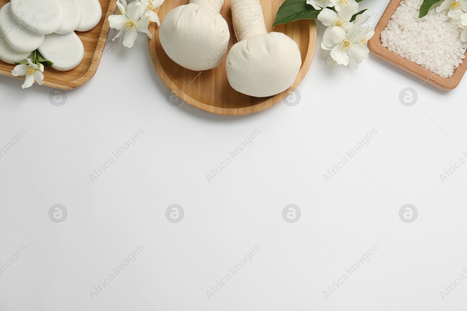 Flat lay composition with spa stones and beautiful jasmine flowers on white background, space for text Photo of Flat lay composition with spa stones and beautiful jasmine flowers on white background, space for text
