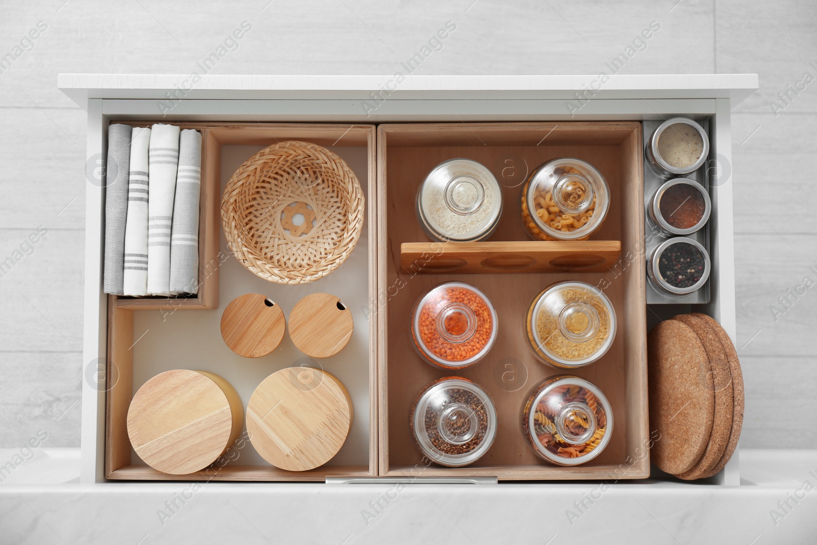 Open drawer with different jars indoors, top view. Order in kitchen Photo of Open drawer with different jars indoors, top view. Order in kitchen