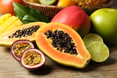 Fresh ripe papaya and other fruits on wooden table Photo of Fresh ripe papaya and other fruits on wooden table