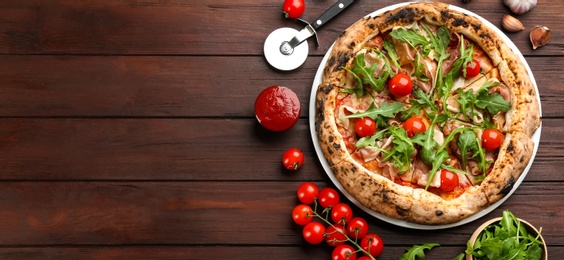 Tasty pizza with meat and arugula on wooden table, flat lay. Space for text Photo of Tasty pizza with meat and arugula on wooden table, flat lay. Space for text