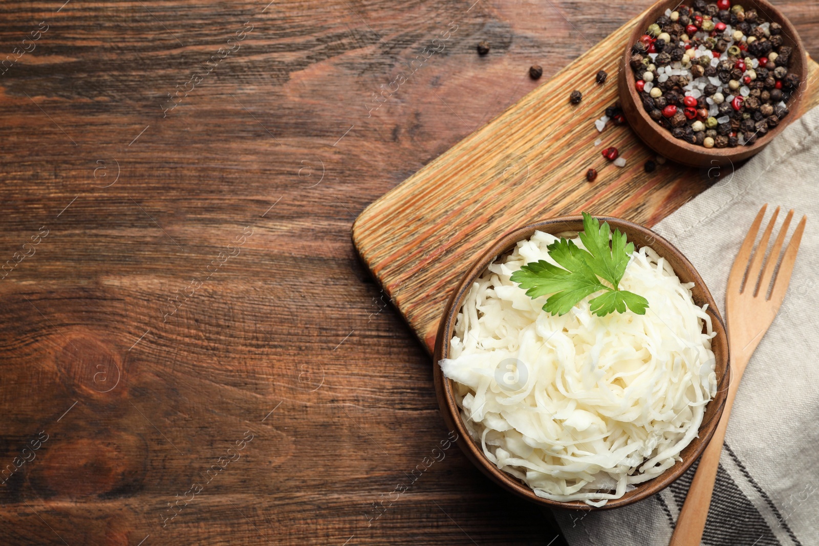 Tasty fermented cabbage on wooden table, flat lay Photo of Tasty fermented cabbage on wooden table, flat lay
