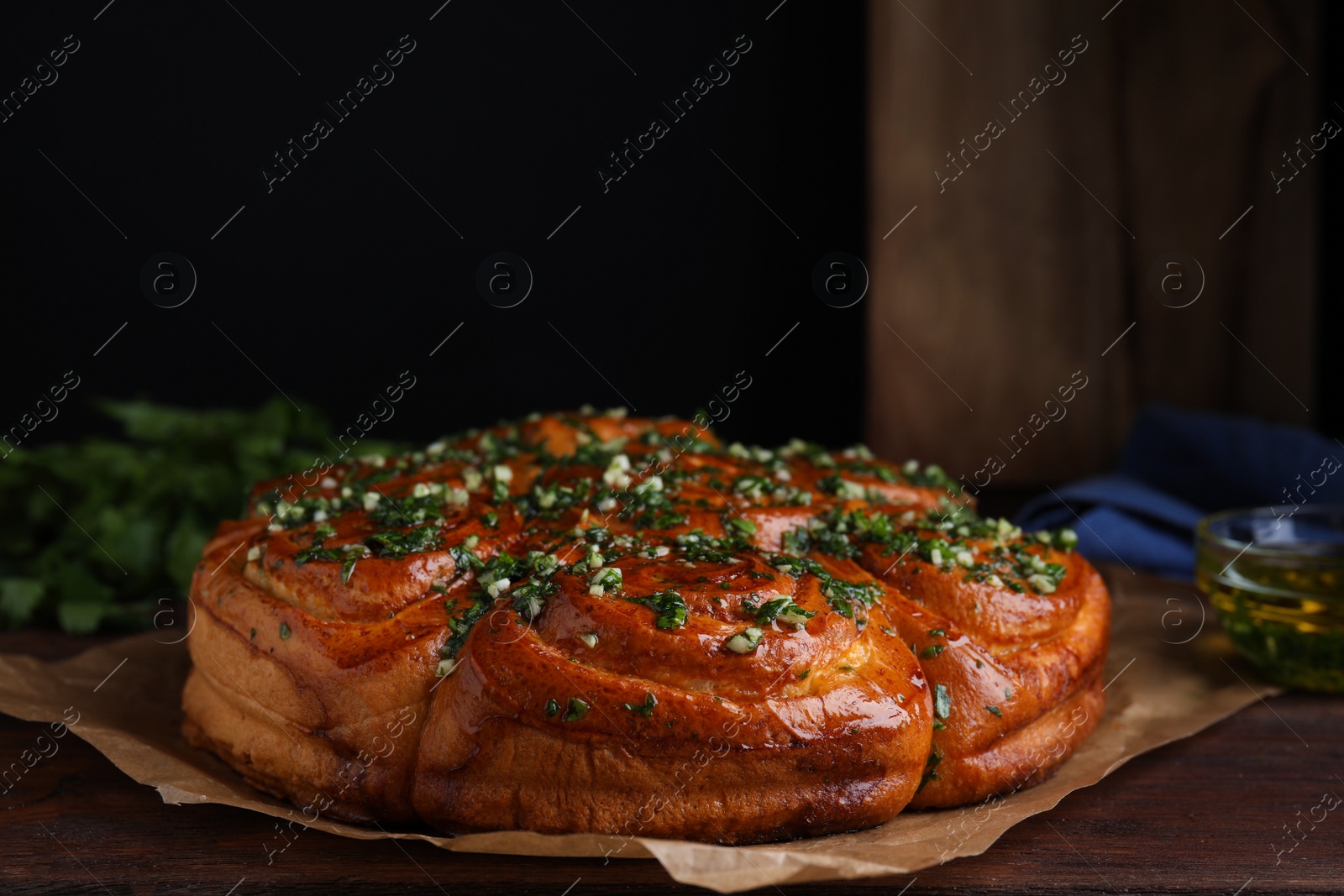 Traditional Ukrainian garlic bread with herbs (Pampushky) on wooden table, closeup Photo of Traditional Ukrainian garlic bread with herbs (Pampushky) on wooden table, closeup