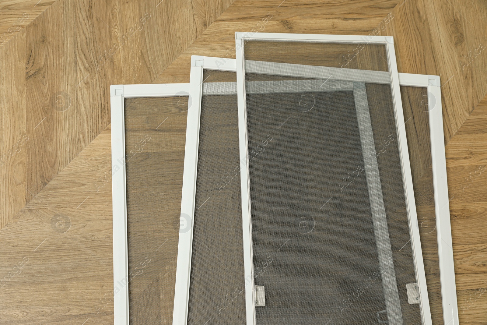 Set of window screens on wooden floor, flat lay Photo of Set of window screens on wooden floor, flat lay